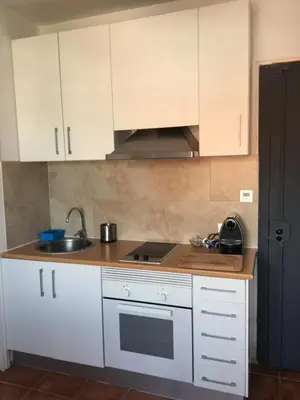 a kitchen with white cabinets and a sink at Beach Castelldefels in Castelldefels
