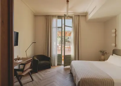 a hotel room with a bed and a desk and a window at Casa Llimona Hotel Boutique in Barcelona