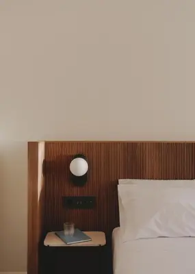 a bed with a nightstand next to a bed with a clock at Casa Llimona Hotel Boutique in Barcelona