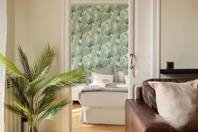a living room with a couch and a plant at Enjoy Apartments Donna in Barcelona