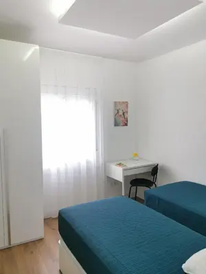 a bedroom with two beds and a desk and a window at Ático in Terrassa
