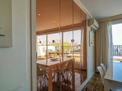 a dining room with a table and a balcony at Sea and Sand Penthouse by Hello Homes Sitges in Sitges