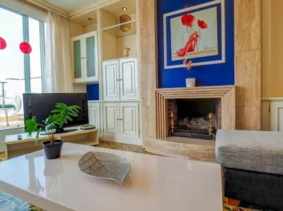 a living room with a white table and a fireplace at Sea and Sand Penthouse by Hello Homes Sitges in Sitges