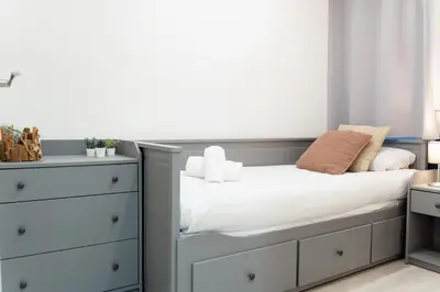 a small bedroom with a bed and a dresser at Refugio playero para 5 personas in Castelldefels