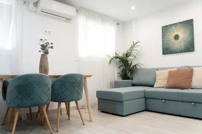 a living room with a couch and a table and chairs at Refugio playero para 5 personas in Castelldefels