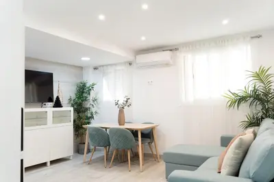 a living room with a table and a blue couch at Refugio playero para 5 personas in Castelldefels