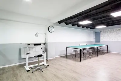 a room with a table and chairs and a clock at Residencia Universitaria Resa Lesseps in Barcelona