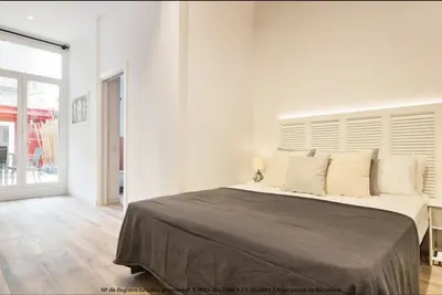 a white bedroom with a large bed with white walls at Catalonia Square Terrace & 5 bathrooms 5BD-5BTH in Barcelona