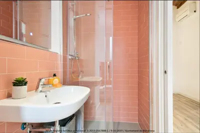 a bathroom with a sink and a shower with pink tiles at Catalonia Square Terrace & 5 bathrooms 5BD-5BTH in Barcelona