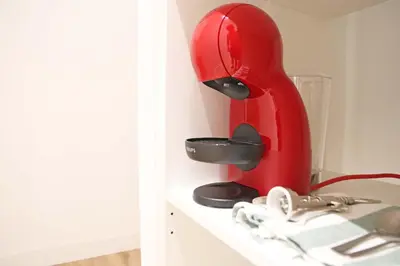a red mixer sitting on top of a shelf at Hostal Gràcia in Barcelona