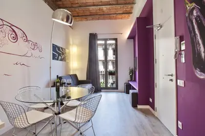 a dining room with a table and chairs and purple walls at Habitat Apartments ADN in Barcelona