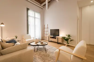 a living room with a couch and a tv at CATERINA Editorial in Barcelona