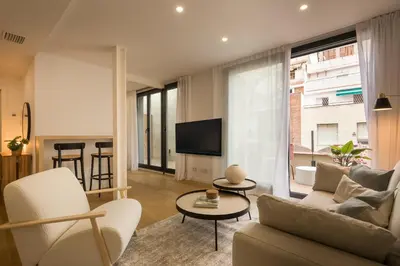 a living room with a couch and a tv at CATERINA Editorial in Barcelona