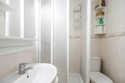 a white bathroom with a sink and a toilet at Consell Cent Apartment II 3 domitorios Eixample in Barcelona