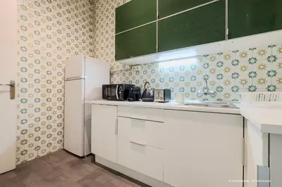 a kitchen with white cabinets and a white refrigerator at Sagrada Familia 360 in Barcelona