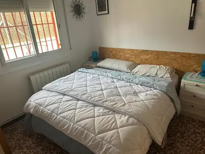 a bedroom with a bed and two windows at Piso superior tranquilo terraza y vistas A 45 min de Barcelona in Cunit