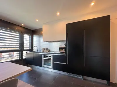 a kitchen with black cabinets and a refrigerator at Stay U-nique Apartments Pau Claris II in Barcelona