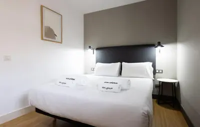 a bedroom with a large white bed with two towels on it at Stay U-nique Apartments Pau Claris II in Barcelona