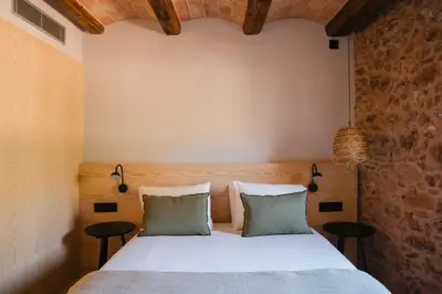 a bedroom with a bed with two pillows at Hotel-Masia Can Farrés in El Bruc
