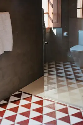 a bathroom with a checkered floor and a toilet at Hotel-Masia Can Farrés in El Bruc