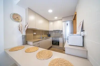 a kitchen with white cabinets and a counter top with two mats at HomeHolidaysRentals Bluemar-Costa Barcelona in Pineda de Mar