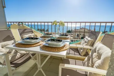 a table with bowls and plates on top of a balcony at HomeHolidaysRentals Bluemar-Costa Barcelona in Pineda de Mar