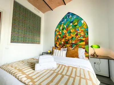 a bedroom with a large bed with a stained glass window at Boutique Lepant in Barcelona