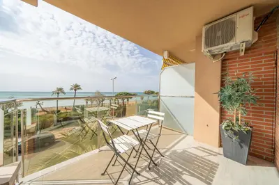 a balcony with chairs and a view of the ocean at HomeHolidaysRentals Noelani- Costa Barcelona in Pineda de Mar