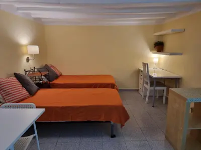 a room with two beds and a table and a desk at Apart 2 beds 1 sofabed downtown 31 nigths min Barcelona in Barcelona