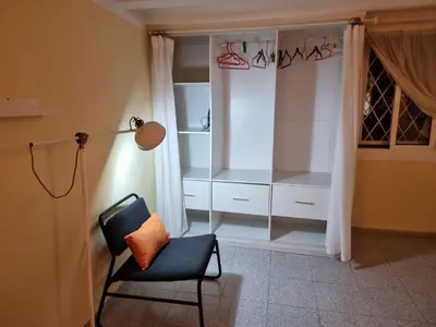 a chair and a lamp in a room with a closet at Apart 2 beds 1 sofabed downtown 31 nigths min Barcelona in Barcelona