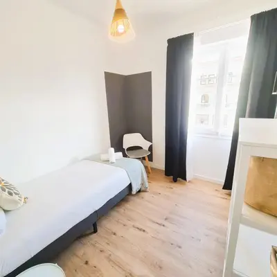 a bedroom with a bed and a chair in it at G74 AVENIDA GAUDI nice 4 bedrooms apartment with balcony with views of the Basilica Sagrada Familia in Barcelona