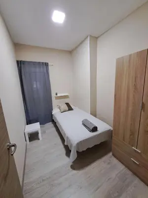 a small bedroom with a bed and a window at MERIDIANA sant andreu 4 bedrooms in Barcelona