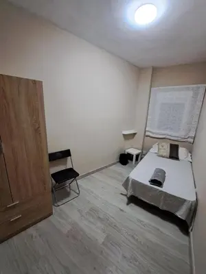a small bedroom with a bed and a chair at MERIDIANA sant andreu 4 bedrooms in Barcelona