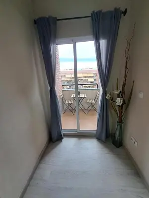 a room with a window with a view of a balcony at MERIDIANA sant andreu 4 bedrooms in Barcelona
