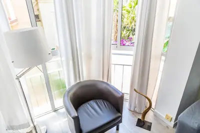 a black chair sitting in front of a large window at Opening Doors Gràcia in Barcelona