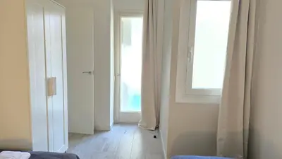 a bedroom with a window and a wooden floor at Opening Doors Gràcia in Barcelona