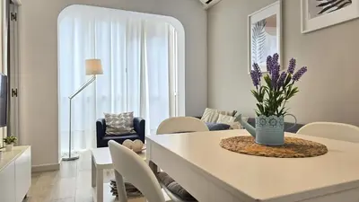 a white living room with a table and chairs at Opening Doors Gràcia in Barcelona