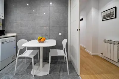a kitchen with a white table and white chairs at Habitat Apartments Arenas Parc in Barcelona