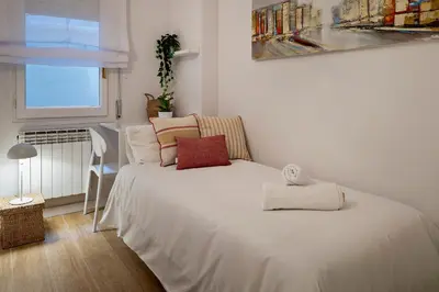 a white bed in a room with a window at Habitat Apartments Arenas Parc in Barcelona