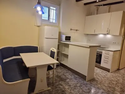 a small kitchen with a small table and a table and a counter at 2 bedrm BCN down AC WIFI 30 nigths min in Barcelona