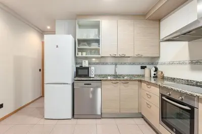 a kitchen with a white refrigerator and cabinets at Ola Living Consell De Cent in Barcelona