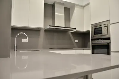 a kitchen with white cabinets and a white counter top at Way to BCN Casa Rovira in Barcelona