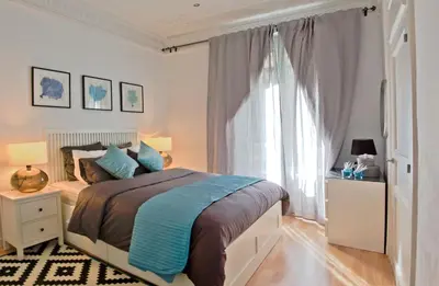 a bedroom with a bed and a large window at Way to BCN Casa Rovira in Barcelona