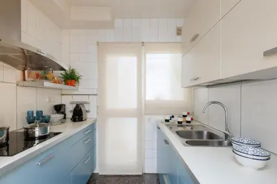 a kitchen with blue and white cabinets and a sink at Housalia Gracia 2 in Barcelona