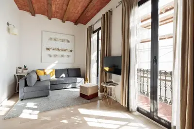 a living room with a couch and a large window at Enjoy Apartments Montserrat Boutique Apartment in Eixample in Barcelona