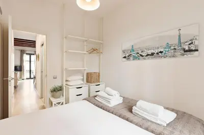 a white bedroom with a large bed with white towels at Enjoy Apartments Montserrat Boutique Apartment in Eixample in Barcelona