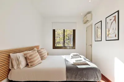 a white bedroom with a large bed with a window at Enjoy Apartments Urban Retreat Valencia 2 in Barcelona