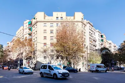a white car driving down a street in front of a building at Enjoy Apartments Urban Retreat Valencia 2 in Barcelona