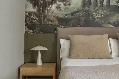 a bedroom with a bed and a painting on the wall at Ola Living Hostal Diagonal in Barcelona