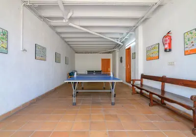 a ping pong table in a room with two benches at Cal Metge de Gualba in gualba de Dalt
